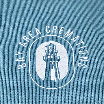 A lighthouse logo embroidered in white on a sage quarter-zip