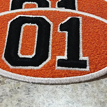 An orange patch with the number 01 in raised black embroidery