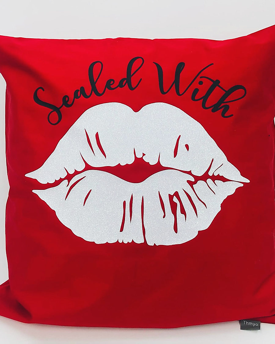 A red Sealed With a Kiss pillow