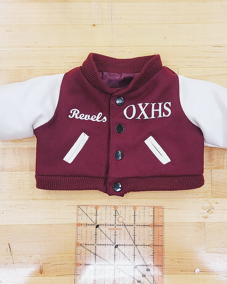 A tiny maroon varsity jacket with a Rebels OXHS patch